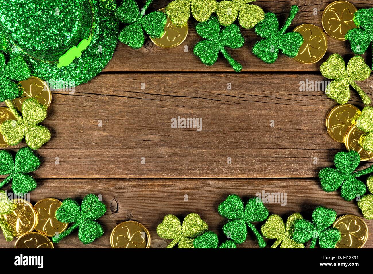 St Patricks Day Rahmen der Shamrocks, Goldmünzen und Leprechaun hat über rustikale Holz Stockfoto