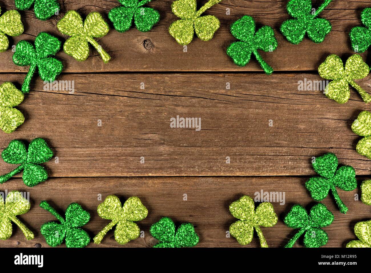 St Patricks Day Rahmen von Glitzerndem shamrocks über ein altes rustikales Holz Hintergrund Stockfoto