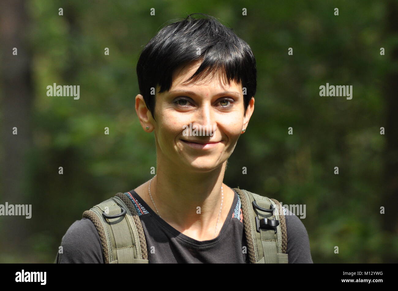 Die Frau unterhalten und nachdenklich. Mädchen mit Ohrringe. Lächeln und Zufriedenheit. Stockfoto