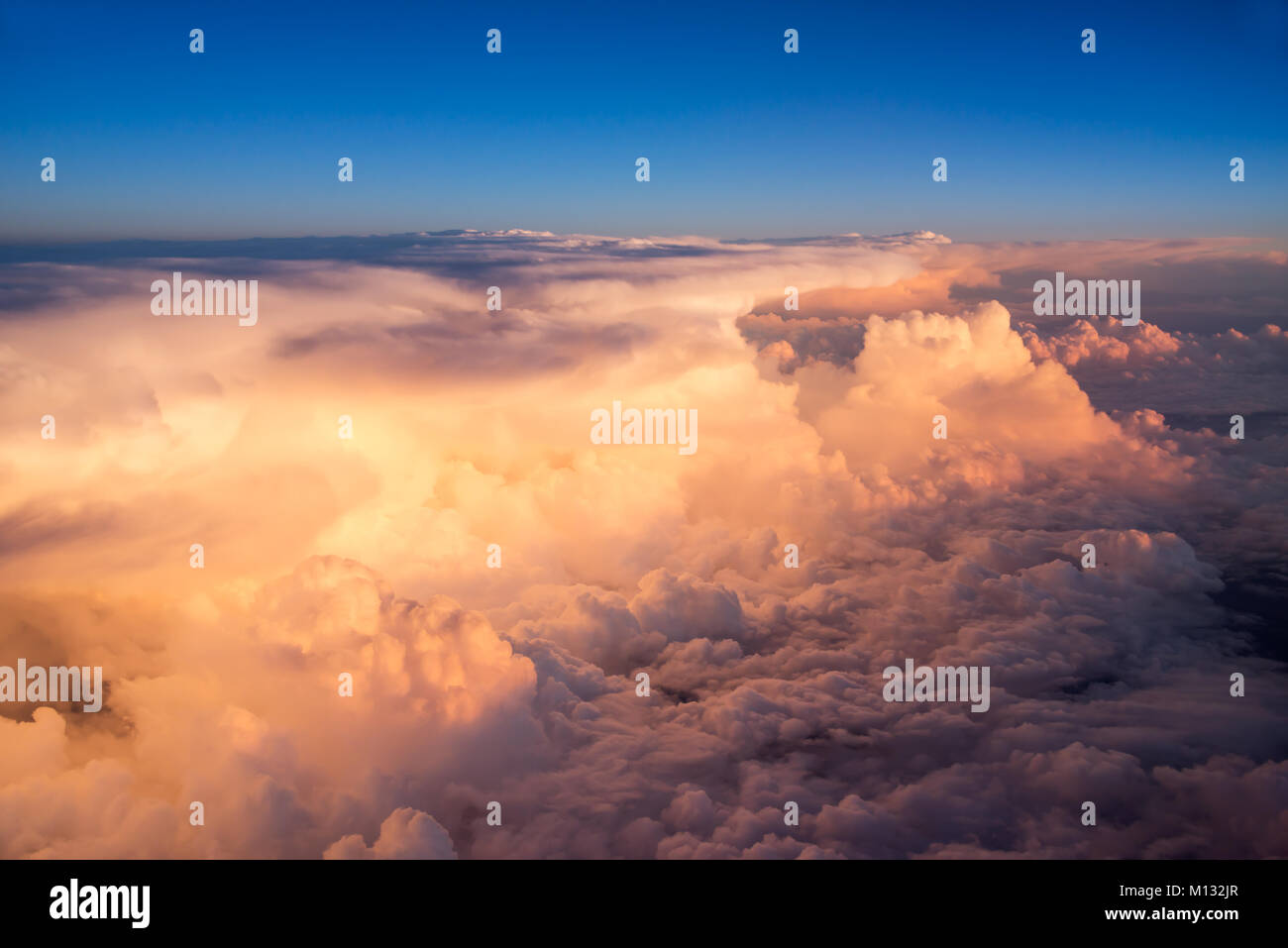 Blick in den Himmel und Wolken aus dem Flugzeug Bullauge bei Sonnenuntergang Stockfoto