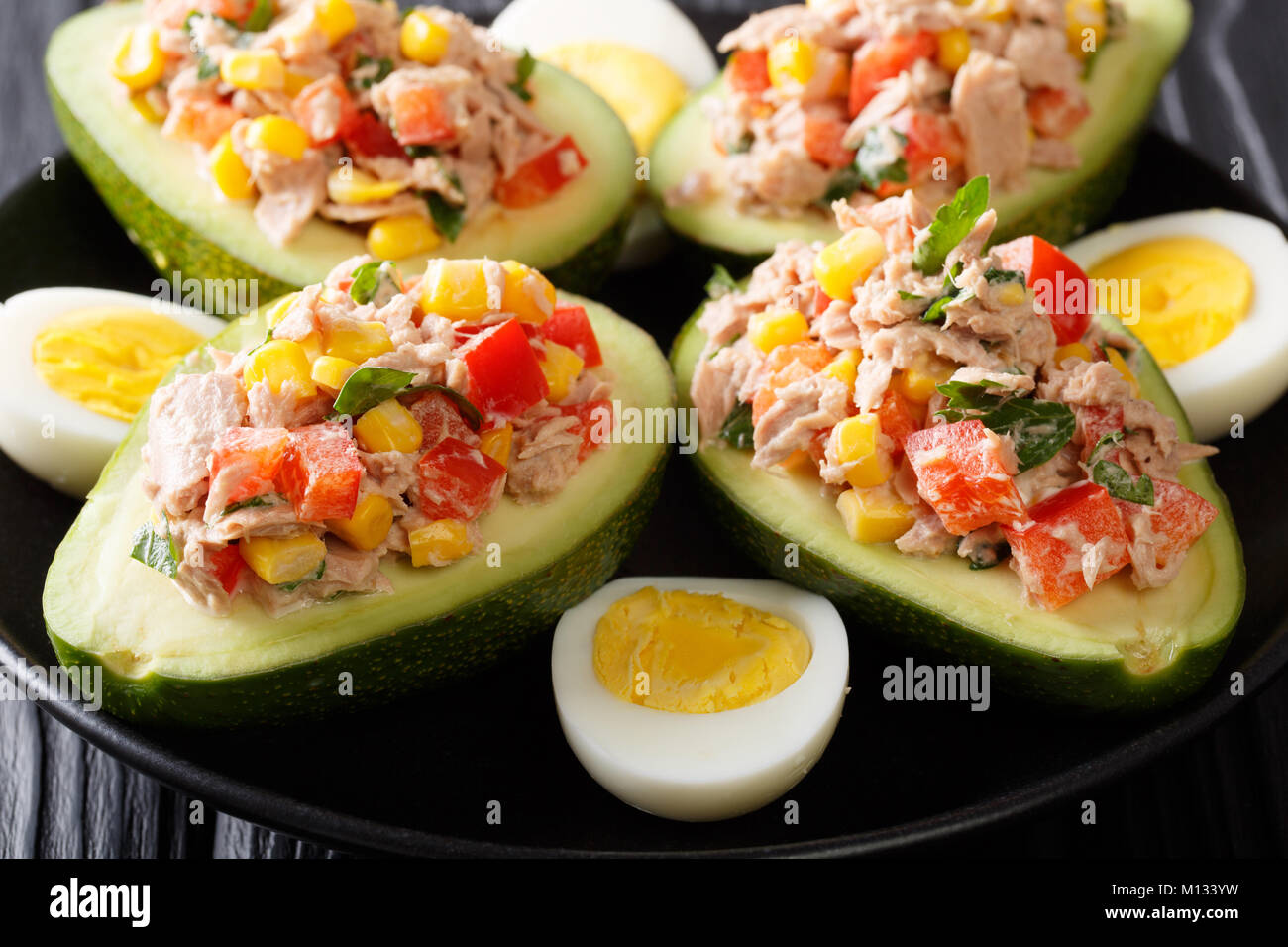 Leckerer snack von Avocado gefüllt mit Thunfisch salat Closeup auf einem Teller. Horizontale Stockfoto