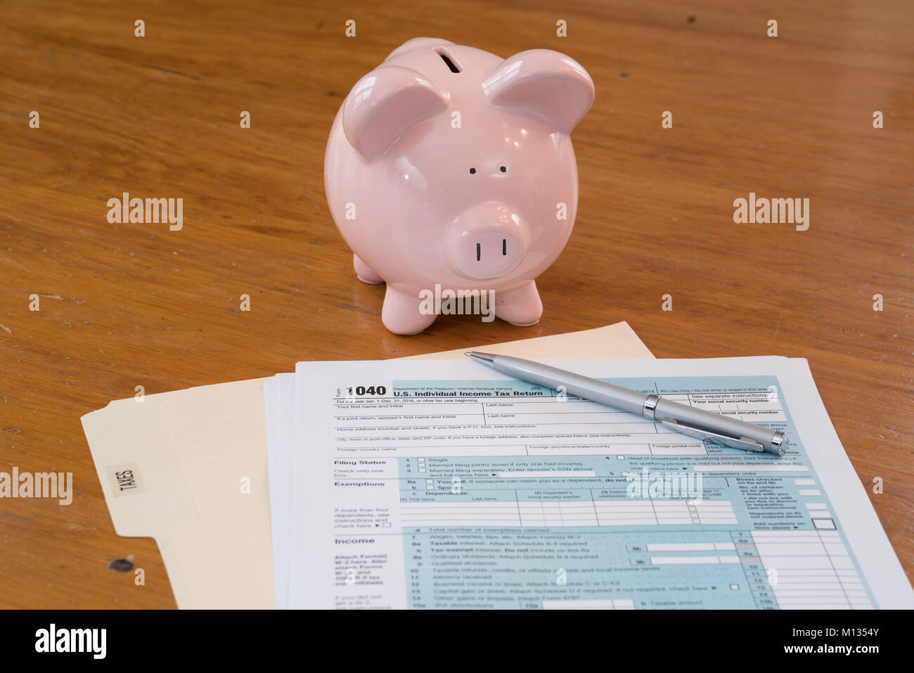 IRS Tax Form mit Sparschwein, Taschenrechner, Stift und Gläser Stockfoto