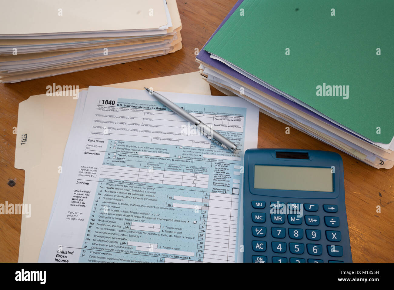 IRS Tax Form mit steuerlichen Unterlagen in Ordnern, Taschenrechner und Kugelschreiber Stockfoto