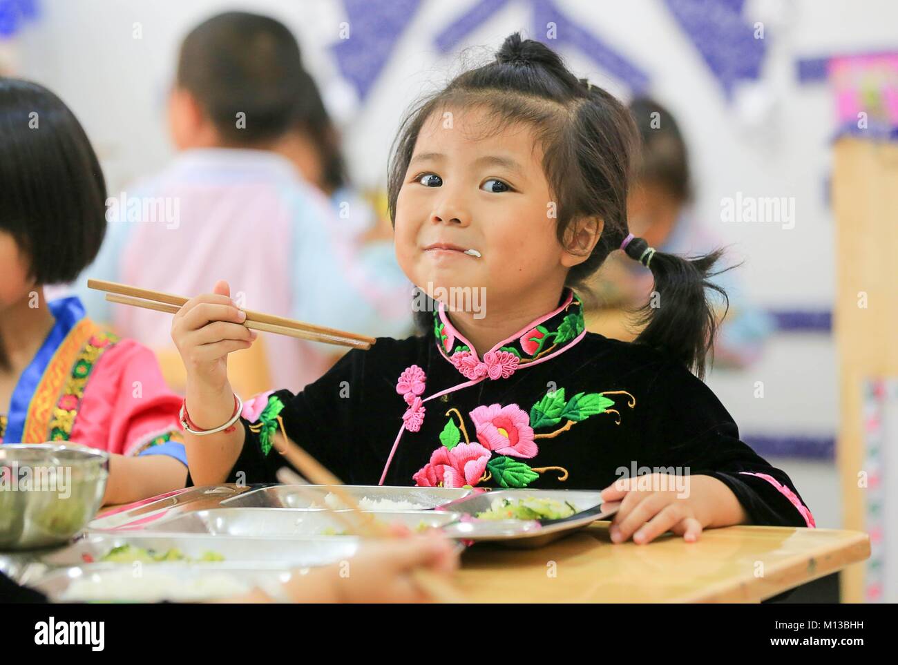 (180126) - Peking, Jan. 26, 2018 (Xinhua) - chinesische Minister für Bildung Chen Baosheng am Dienstag versprochen, die Ausgaben der öffentlichen Hand und Unterstützung für vorschulische Bildung zu erhöhen. Das Ministerium wird ein Standard für die öffentlichen Ausgaben auf staatliche Kindergärten und Subventionen für private Kindergärten für jedes Kind. Und Maßnahmen werden Gehälter und Nutzen für die Vorschule Lehrer zu garantieren und ihre beruflichen Qualifikationen zu erhöhen. Datei Foto auf Sept. 6, 2017 zeigt, dass die Pan Chengyue, ein 4-jähriges Mädchen von Miao ethnische Gruppe, kostenloses Mittagessen in der Kaihuai Gemeinschaft Nr. 13 Kin Stockfoto