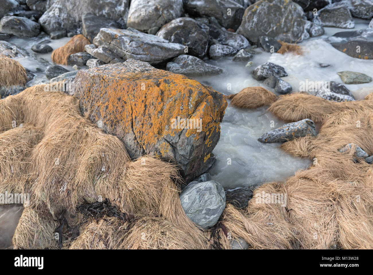 Gefrorene Strand mit Steinen am Ullsfjord in Troms County, Norwegen Stockfoto