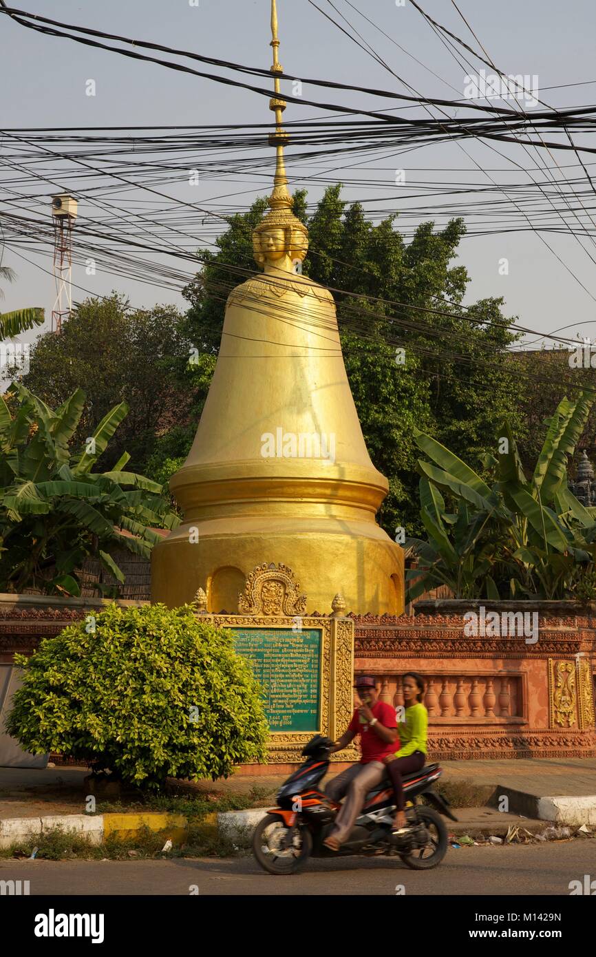 Kambodscha, Battambang, Yong Paar auf Roller vorbei vor einer goldenen Stupa einen buddhistischen Tempel Stockfoto