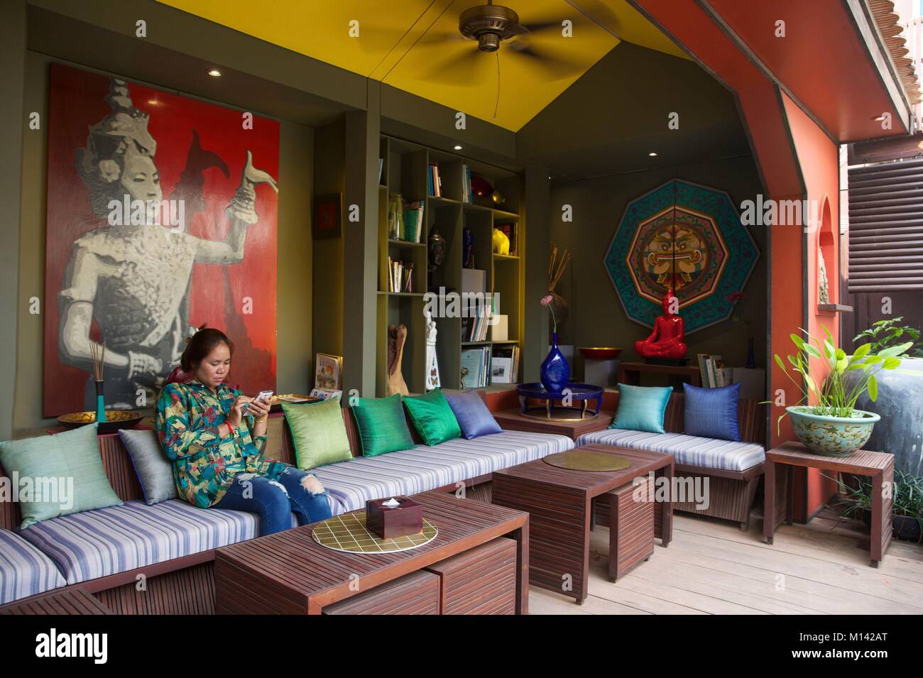 Kambodscha, Siem Reap, Frau im Coffe Shop mit lackiertem Gemälde im Haus Shop des theam eingerichtet sitzen Stockfoto