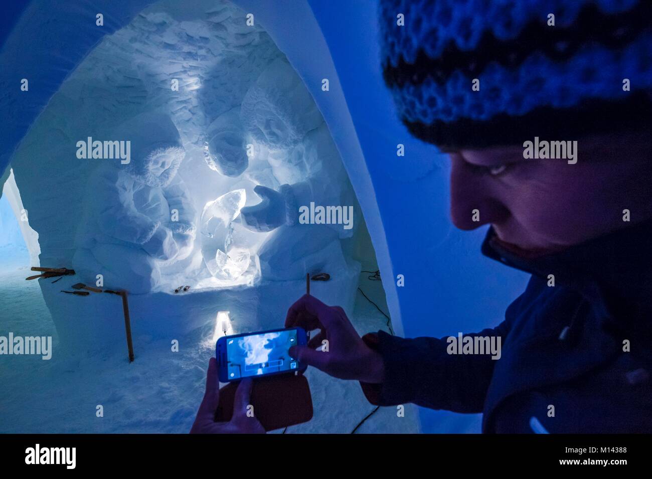 Frankreich, Savoyen, Tarentaise, Vanoise, Bögen 2000 Ski Resort, Manon CHERPE nimmt ein Bild von einem Ihrer Skulpturen, einem traditionellen Inuit fischen Szene im Schnee Wand der Iglu-dorf Skulptur Galerie, in der Wintersaison 2017-2018 Stockfoto