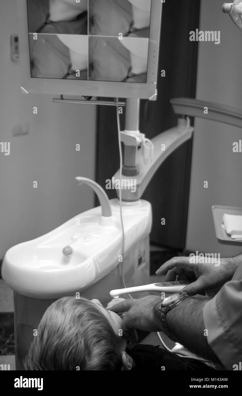 Zahnarzt heilt die Zähne der kaukasischen Jungen Stockfoto