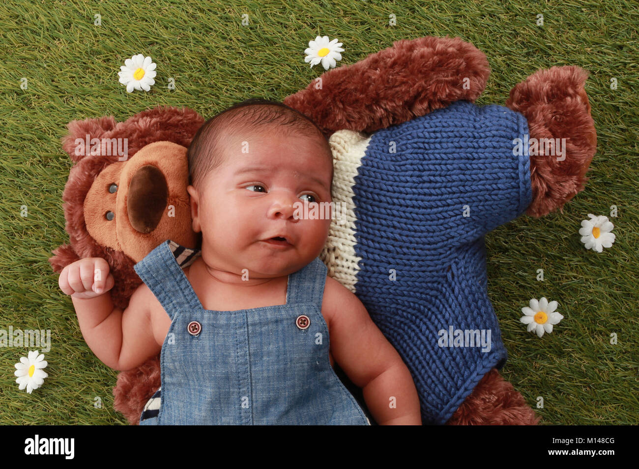 Neugeborene 3 Woche alt gemischt Rennen baby boy im Garten entspannen mit Teddy Stockfoto