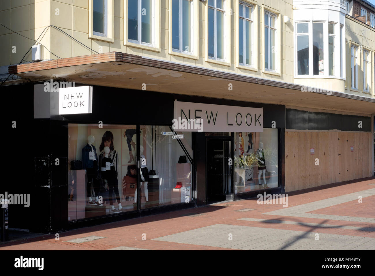 Einen neuen Look Store steht neben einer Linie der Verbrettert Geschäfte in Palmerston Road southsea England Großbritannien Stockfoto