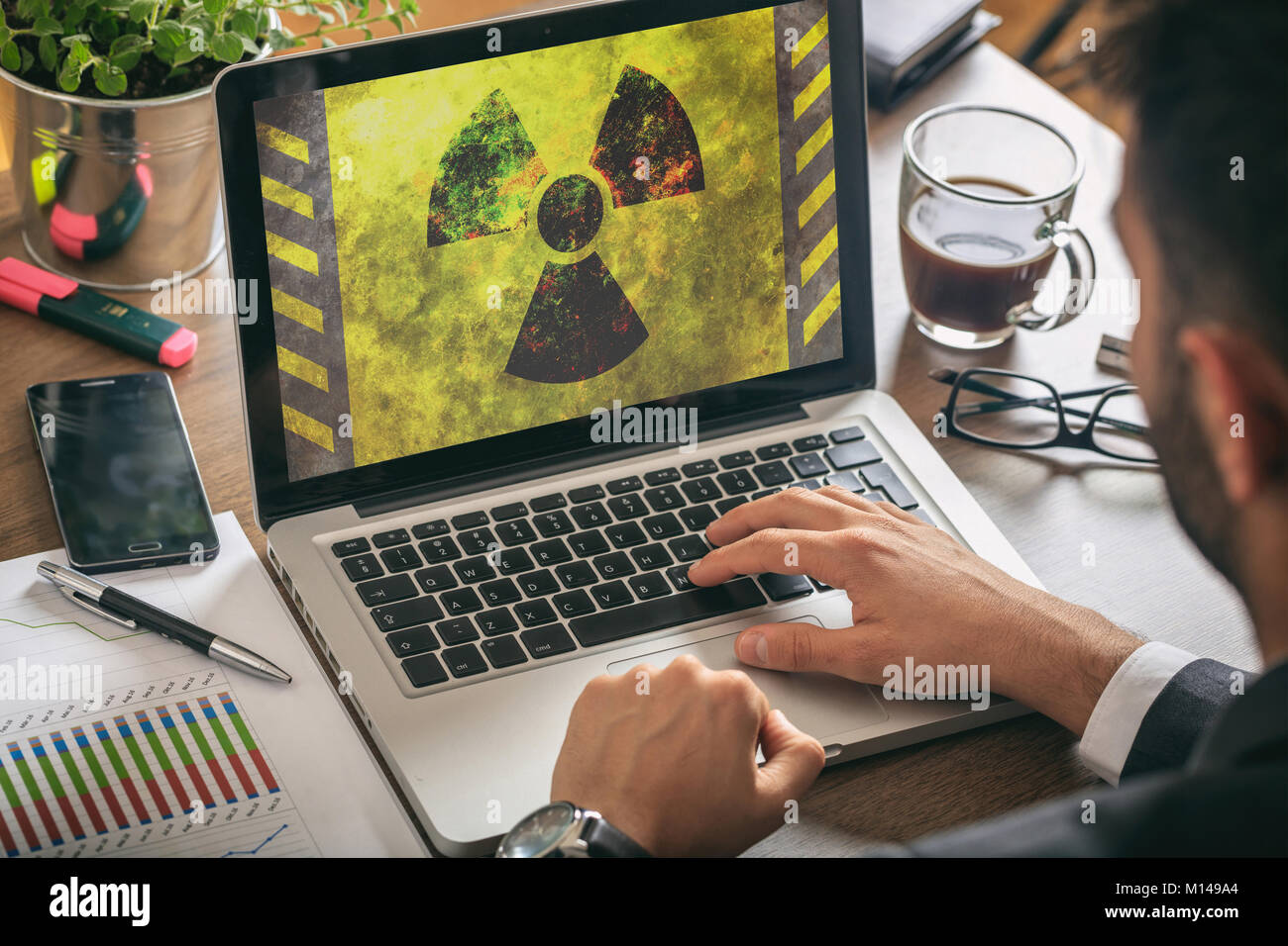Mann bei der Arbeit im Büro, Strahlung Symbol auf dem Laptop Bildschirm, Stockfoto