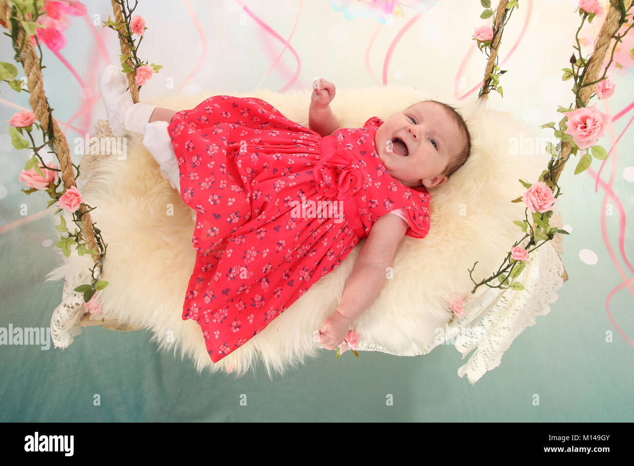 6 Wochen alten Baby Mädchen in rosa Kleid auf die sensorische Schwingen  Stockfotografie - Alamy