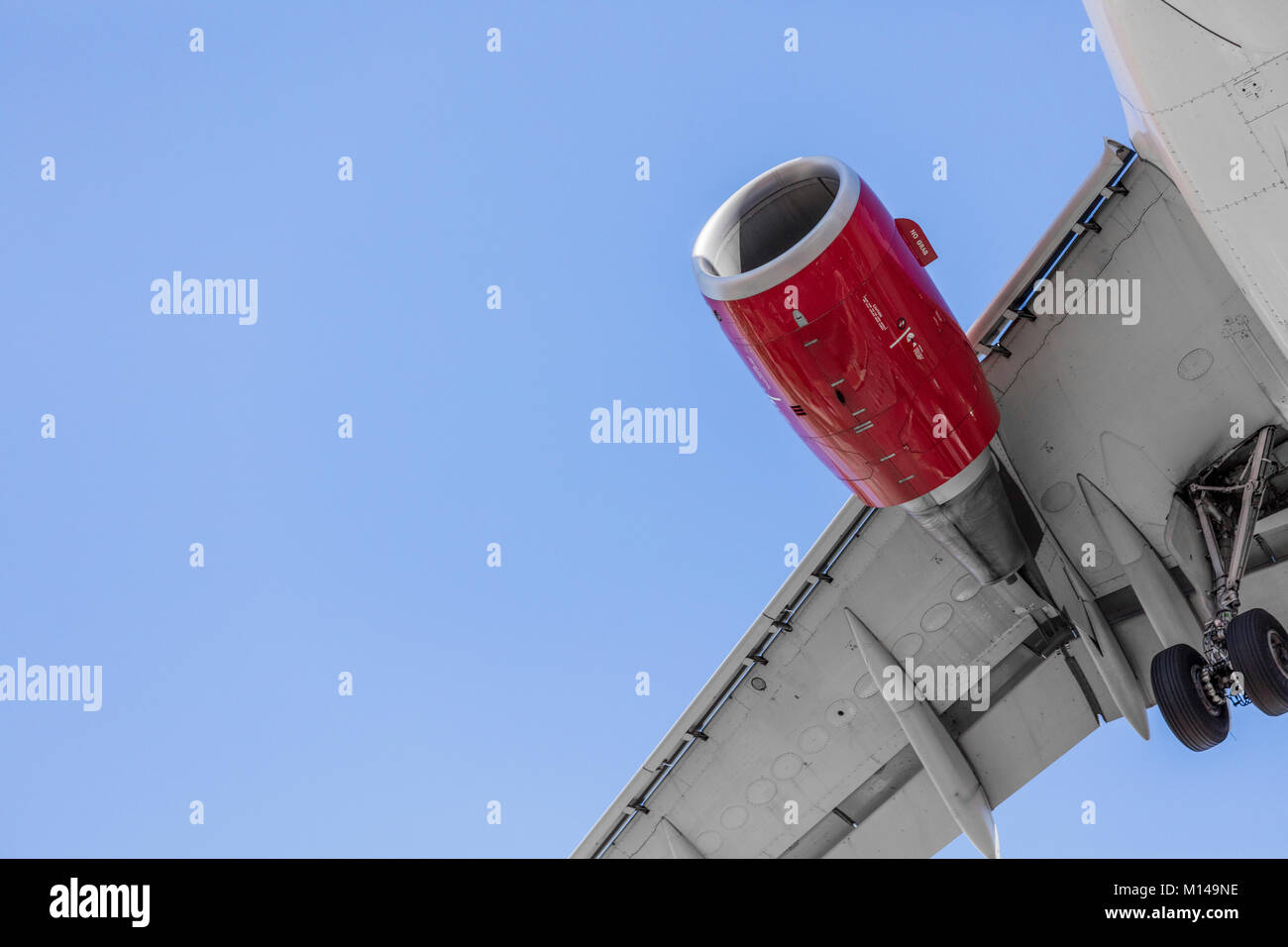 Commercial Passenger Jet zur Landung ab unter dem Flugzeug gesehen. Das Fahrwerk wird abgesenkt Stockfoto