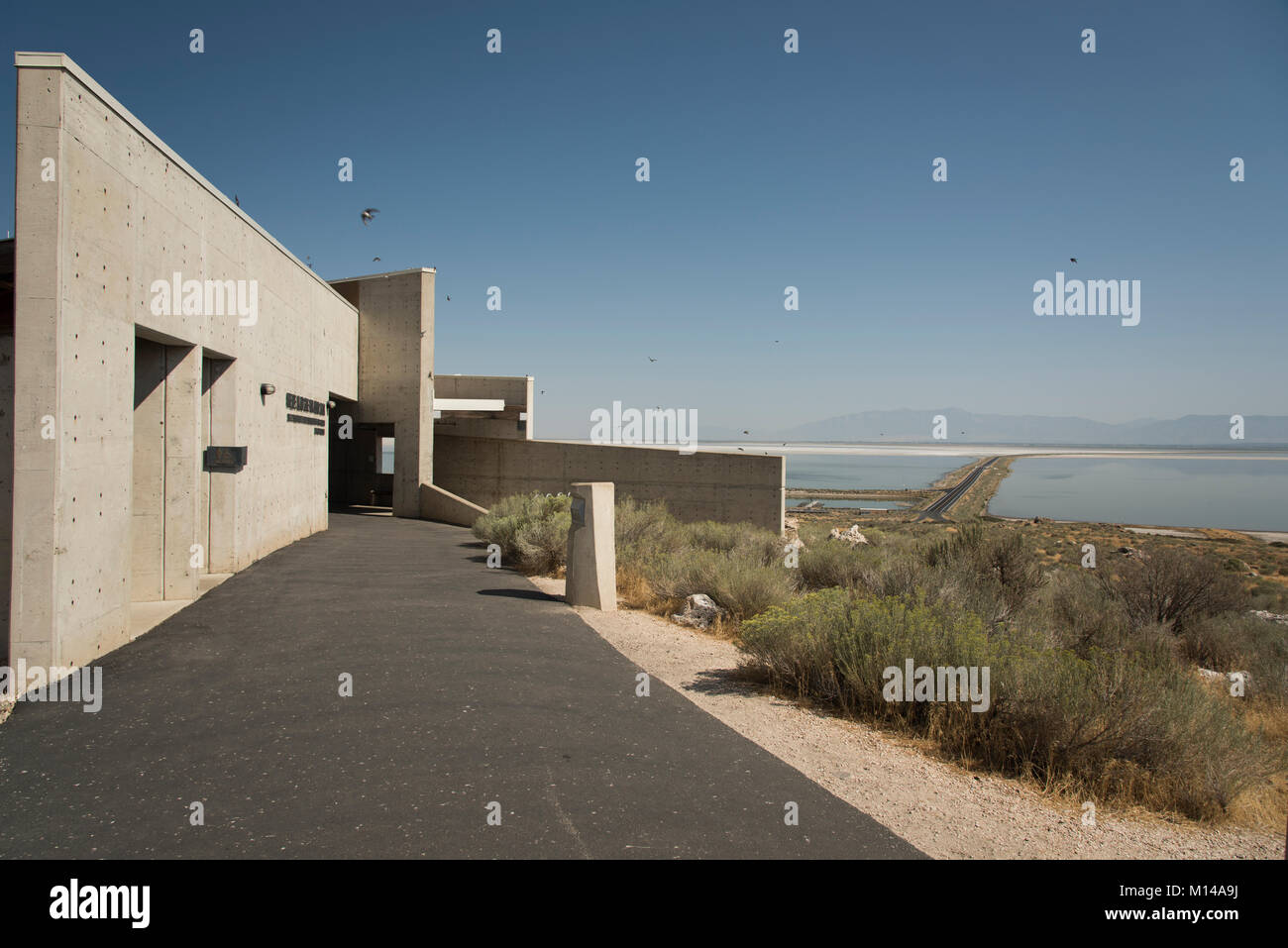 Die Annäherung an das Besucherzentrum am Antelope Island am Great Salt Lake, mit dem Davis County Causeway im Hintergrund. Stockfoto