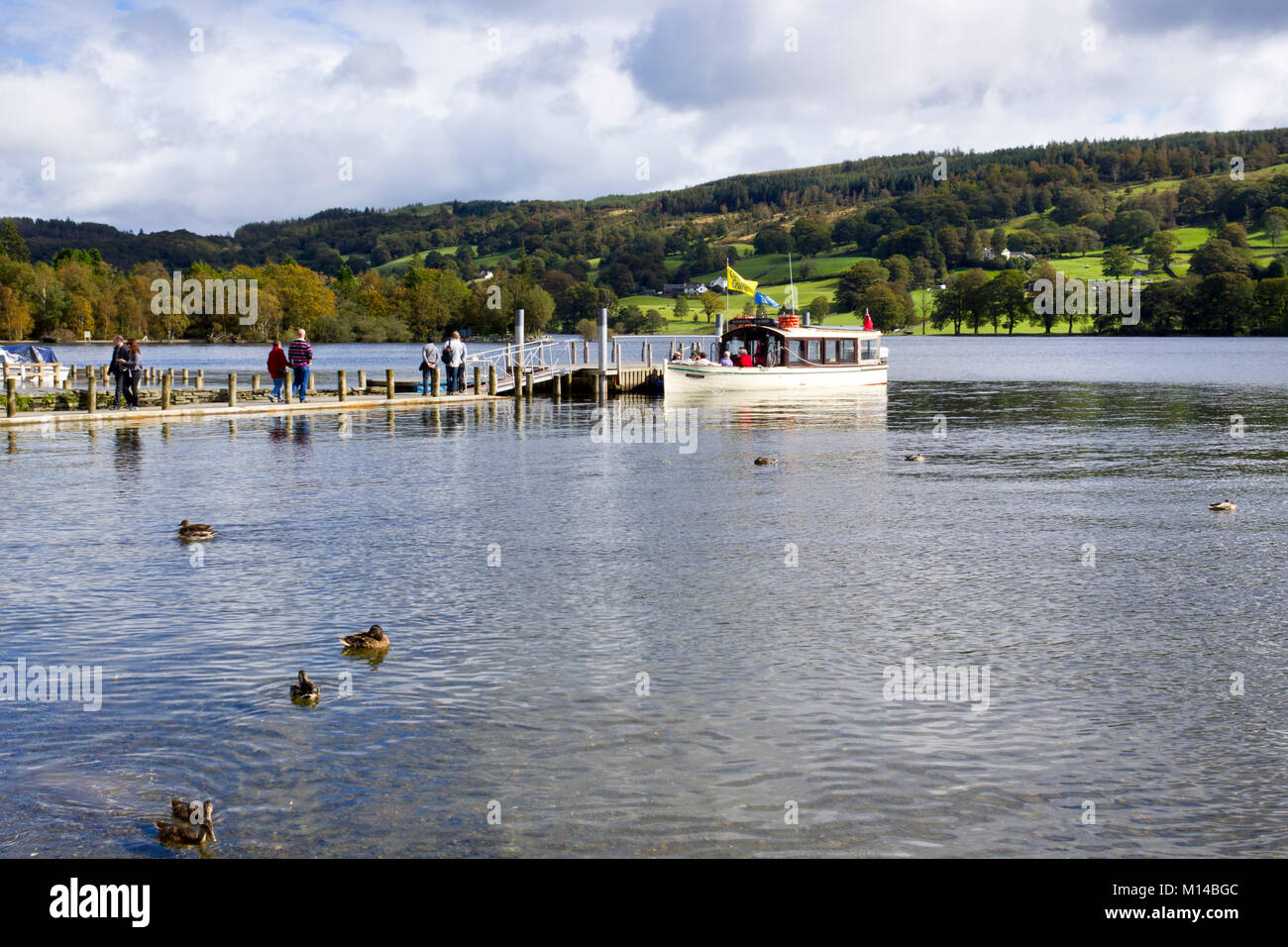 Coniston, Großbritannien - 14.. September 2011: In der Herbstsonne wartet ein Sightseeing-Boot auf Passagiere, die von einem Anlegesteg in der Nähe des Dorfes Coniston auf dem Coniston Water im Lake District National Park, Cumbria, Großbritannien, an Bord gehen. Coniston Water ist der drittgrößte See im englischen Lake District. Stockfoto