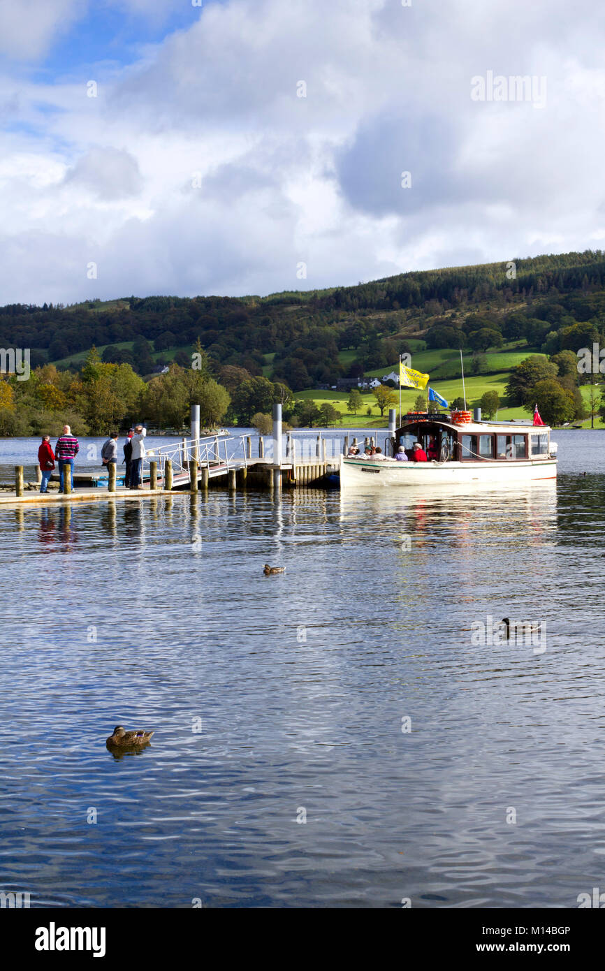 Coniston, Großbritannien - 14.. September 2011: In der Herbstsonne wartet ein Sightseeing-Boot auf Passagiere, die von einem Anlegesteg in der Nähe des Dorfes Coniston auf dem Coniston Water im Lake District National Park, Cumbria, Großbritannien, an Bord gehen. Coniston Water ist der drittgrößte See im englischen Lake District. Stockfoto