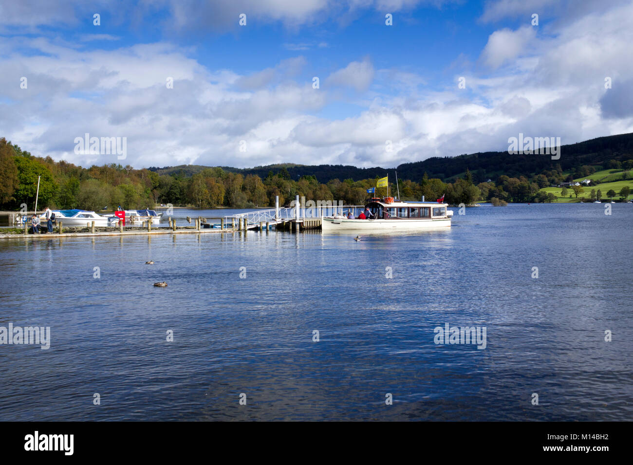 Coniston, Großbritannien - 14.. September 2011: In der Herbstsonne wartet ein Sightseeing-Boot auf Passagiere, die von einem Anlegesteg in der Nähe des Dorfes Coniston auf dem Coniston Water im Lake District National Park, Cumbria, Großbritannien, an Bord gehen. Coniston Water ist der drittgrößte See im englischen Lake District. Stockfoto