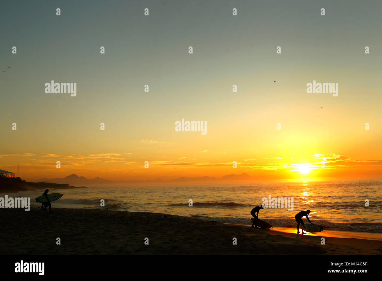 Surfer an Praia do Diabo, in der Nähe von Arpoador bei Sonnenaufgang, Ipanema, Rio de Janeiro, Brasilien Stockfoto
