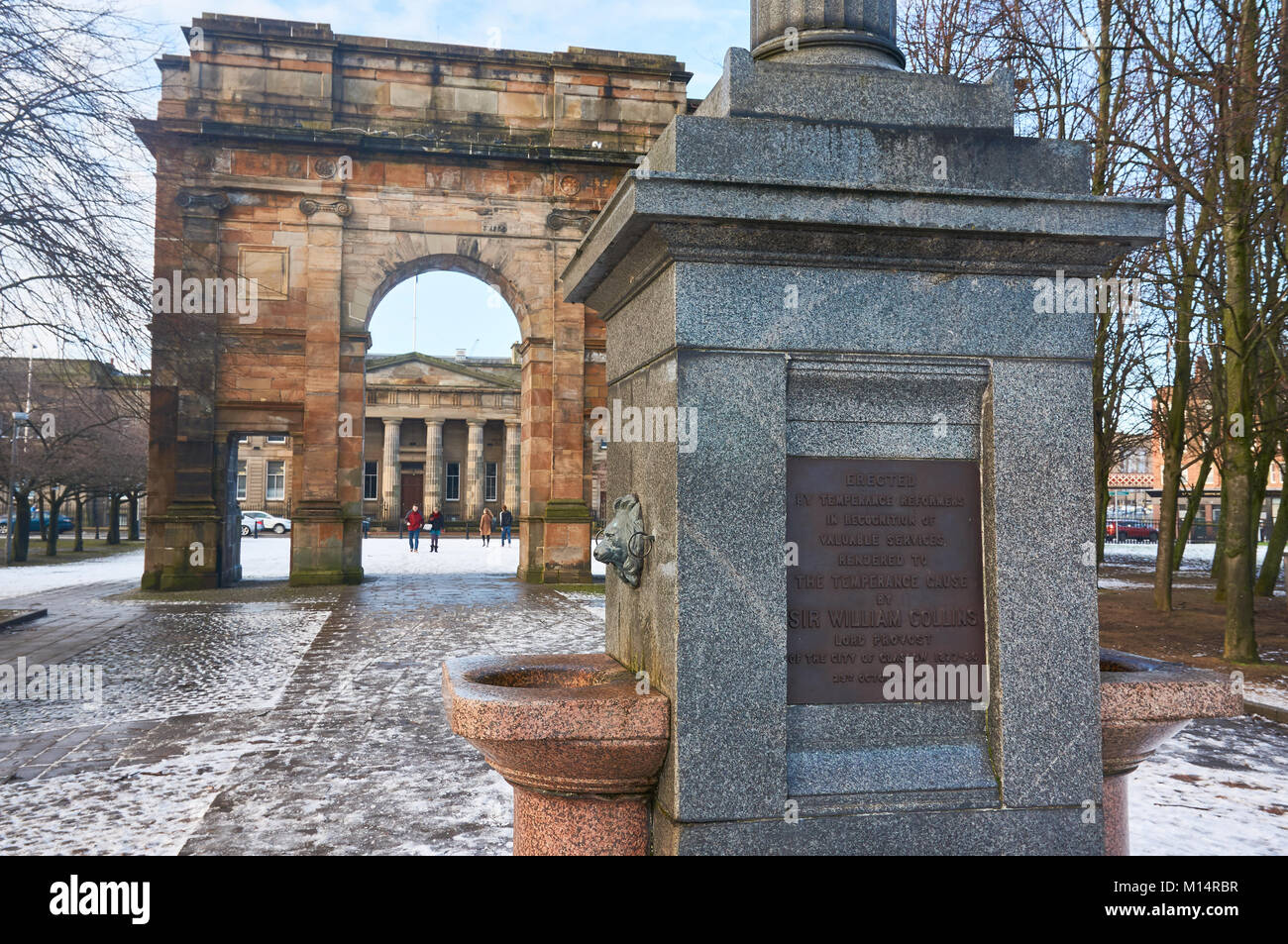 Sir William Collins Brunnen am Eingang zu Glasgow Green Park, mit mit dem McLennan Arch im Hintergrund. Stockfoto