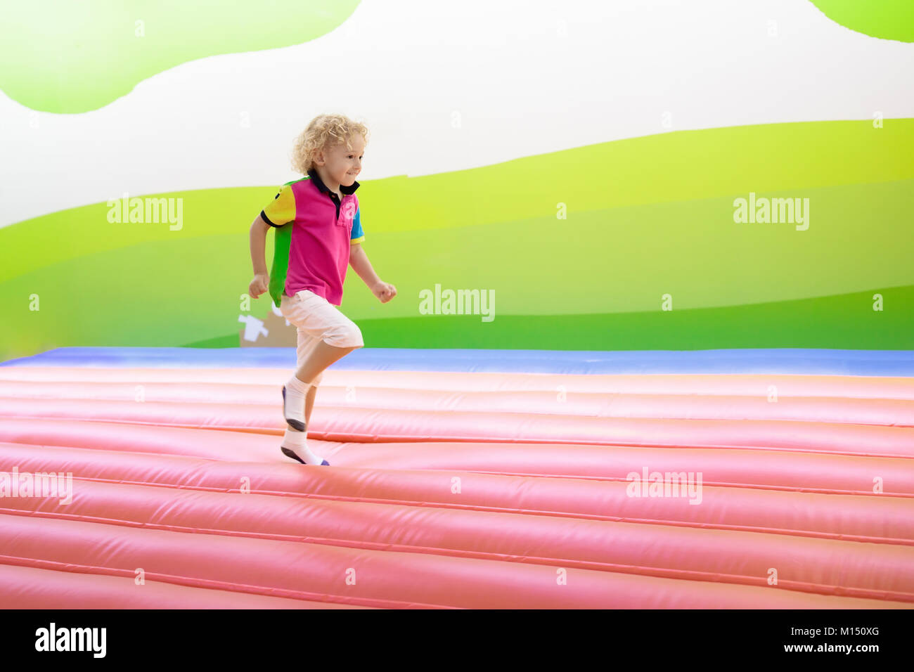Kind springen auf bunten Spielplatz Trampolin. Kinder springen in Aufblasbare bounce Burg auf Kindergarten Geburtstag. Aktivität und spielen Zentrum für Yo Stockfoto