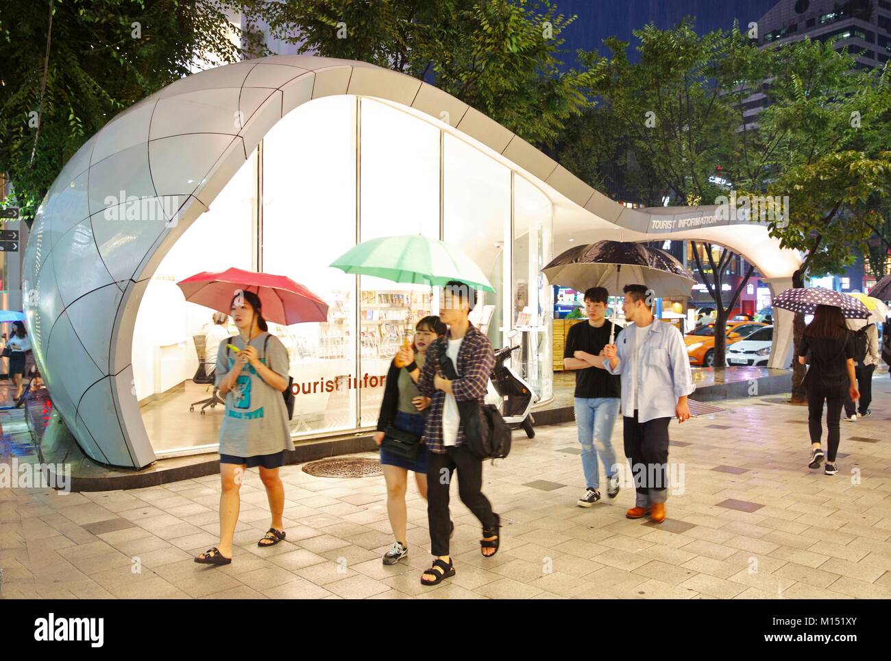 Südkorea, Seoul, Jugendliche, Schirme in der Hand, in der Schriftart des desing Tourismus Büro im trendigen Viertel von Hongdae Stockfoto