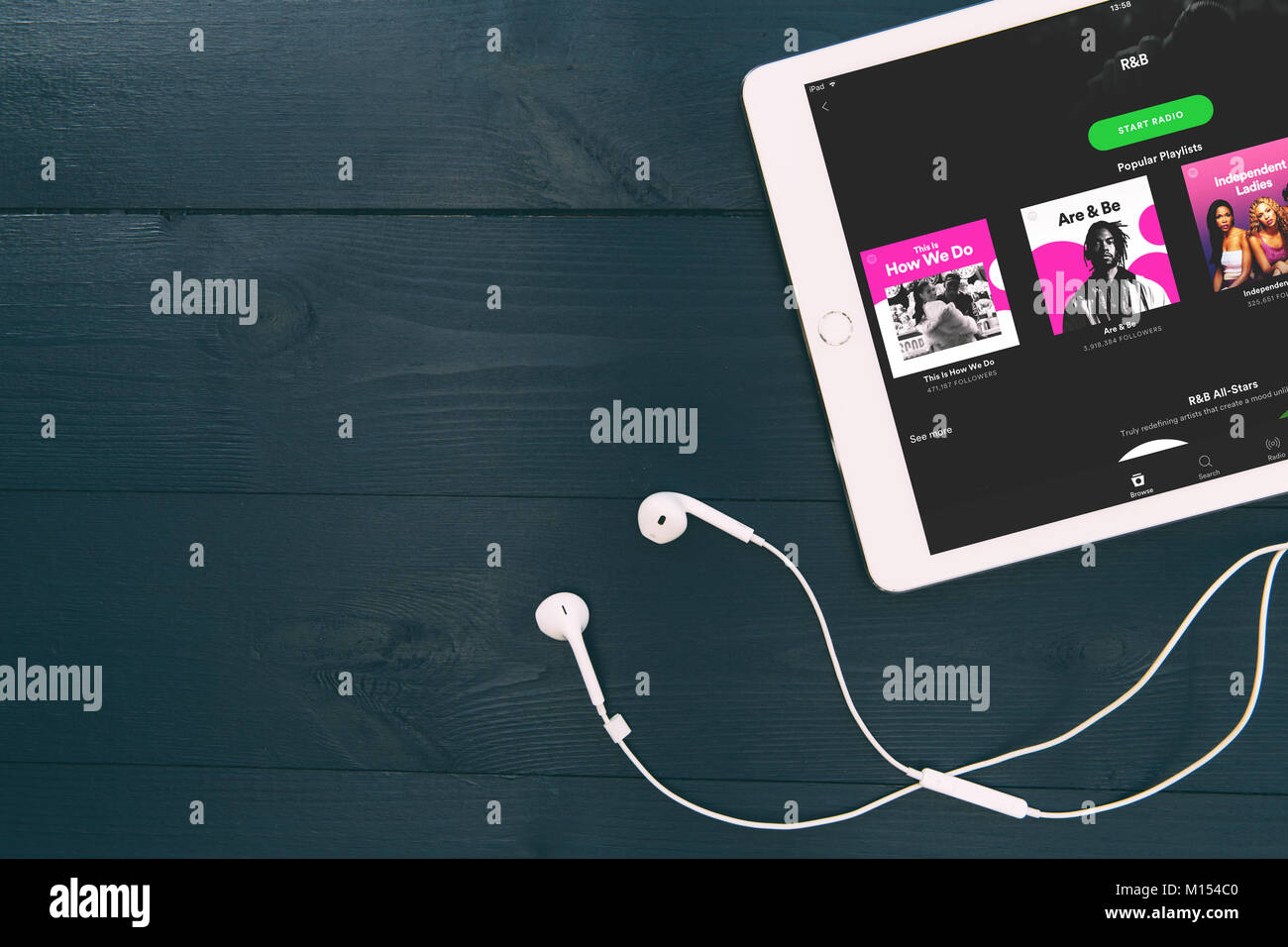 LONDON - Januar 25, 2018: Musik Ohrhörer und Spotify Musik Streaming app Logo auf weißem iPad Tablet Stockfoto