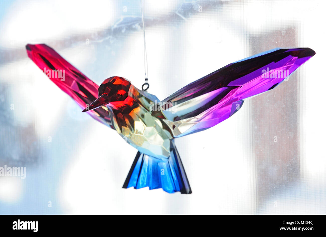 Ein Kristall Kolibri hängend im Fenster. Stockfoto