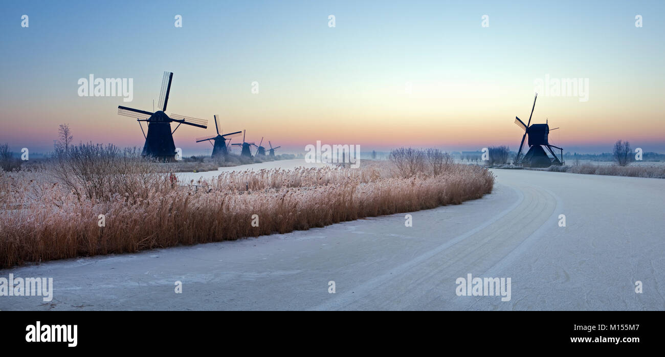 Die Niederlande, Kinderdijk, Windmühlen, UNESCO-Weltkulturerbe. Winter. Panoramablick bei Sonnenaufgang. Stockfoto
