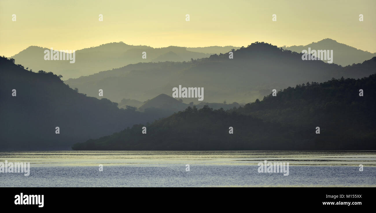 Dämmerung vor Sonnenaufgang auf dem Ozean Küste. Meer und Berge Landschaft am nebligen Morgen. Insel Komodo. Molukken, indonesischen Molukken, Spice Isla Stockfoto