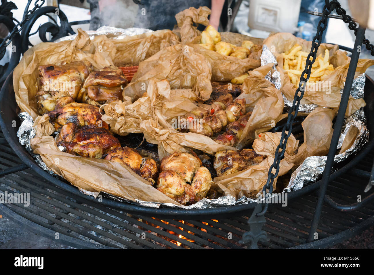 Straßenküche. Großer Grill mit Fleisch. Gebratene Rippchen, Hühnchen, Schweinefleisch, truthahn, Bratkartoffeln. Stockfoto