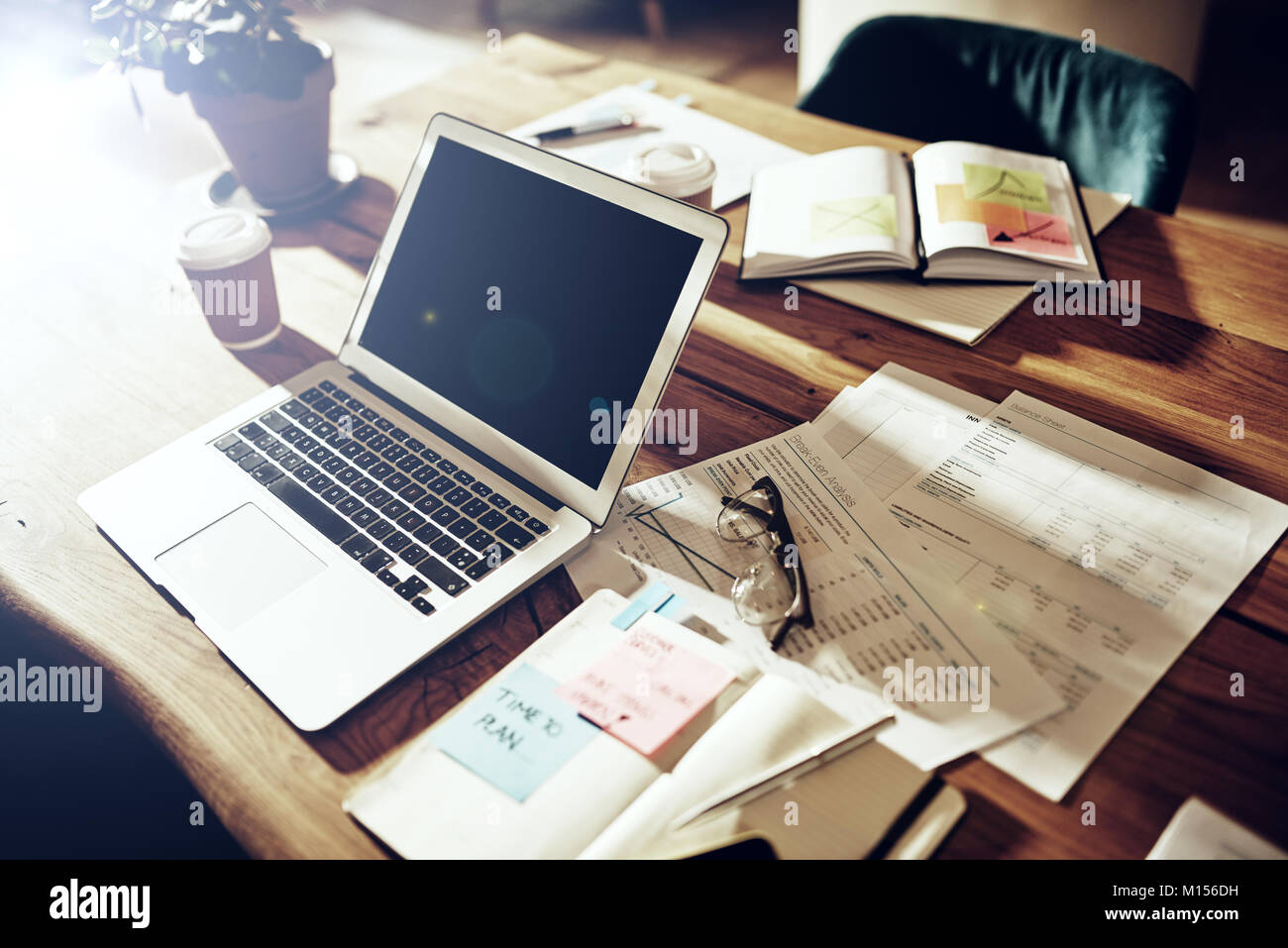 Innenraum einer Tabelle in einem Büro nach Stunden mit einem Laptop, Notebook und fallen in die Unterlagen und Dokumente Stockfoto