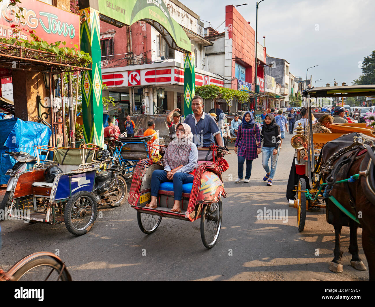 Rikscha mit Passagier in der Malioboro Street. Yogyakarta, Java, Indonesien. Stockfoto