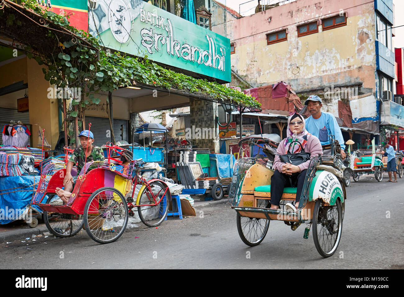 Cycle rickshaw mit seinem Passagier auf Malioboro Street entfernt. Yogyakarta, Java, Indonesien. Stockfoto