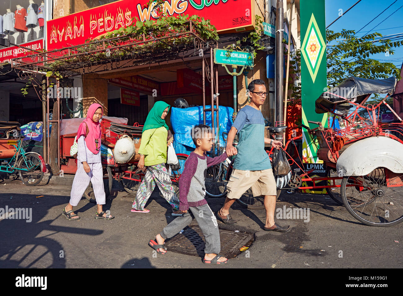 Asiatische Familie zusammen Malioboro Street entlang zu laufen. Yogyakarta, Java, Indonesien. Stockfoto