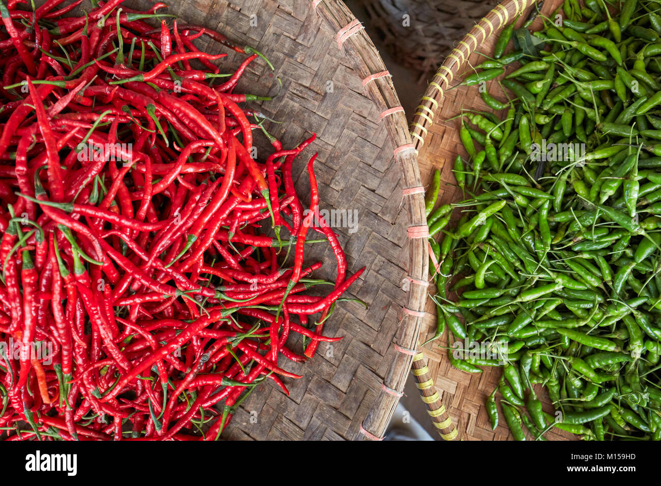Körbe mit roten und grünen Paprika zum Verkauf an Beringharjo (Pasar Beringharjo). Yogyakarta, Java, Indonesien. Stockfoto