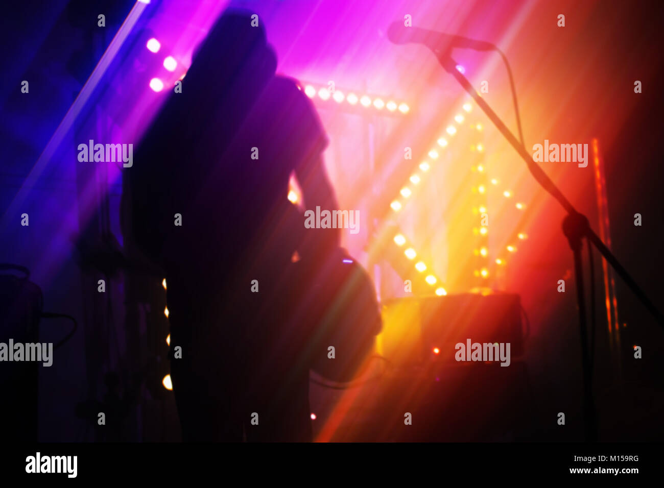 Farbenfrohe verschwommen Rock Musik Abstract Background, Bass Guitar Player auf einer Bühne Stockfoto