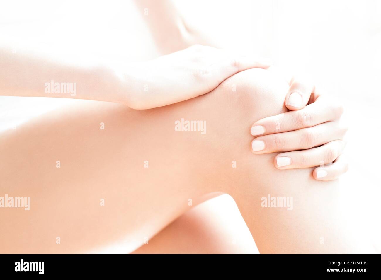 MODEL RELEASED. Junge Frau in Schmerzen ihrer wunden Knie rieb. Stockfoto