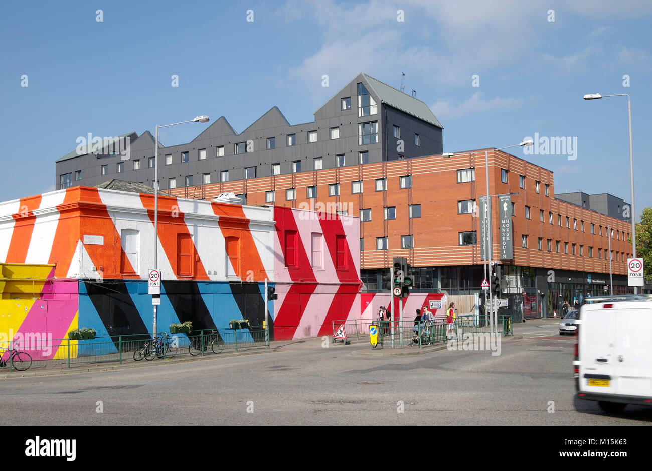 Gruppe von leeren Häusern in Breiten diagonalen Streifen in Rot, Weiß und Orange Lack lackiert, neue massive Block von Studentenwohnungen hinter Stockfoto
