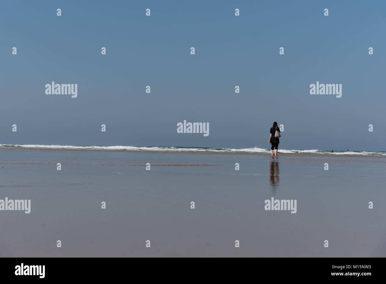 Dame auf einem leeren Strand Blick auf Meer und Himmel Stockfoto