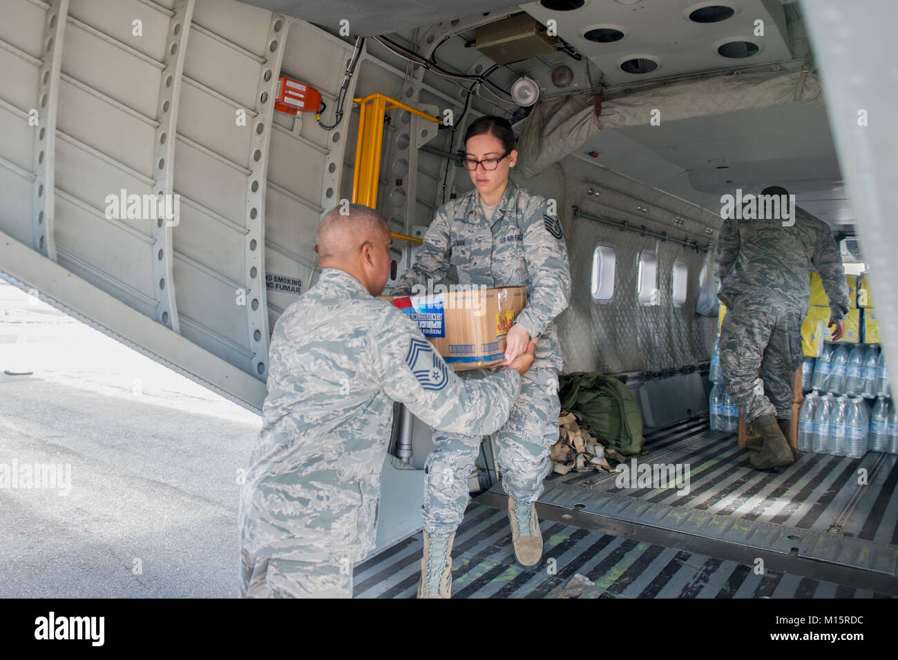 Tech Sgt. Stephany Guzman, ein Budget Analytiker mit der 156 Airlift Wing, verläuft auf einem Kasten Hilfsgüter, November 22, 2017, auf der Isla Grande Flughafen, Puerto Rico. Die Dominikanische Republik aircrew gelieferten Hilfsgüter nach Puerto Rico Wachposten während ihrer Genesung zu unterstützen. (U.S. Air National Guard Stockfoto