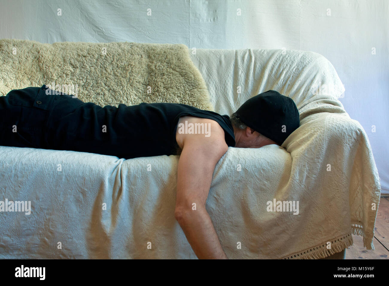 Symbol Bild Alkohol, Mann mit Kater auf dem Sofa liegend Stockfoto