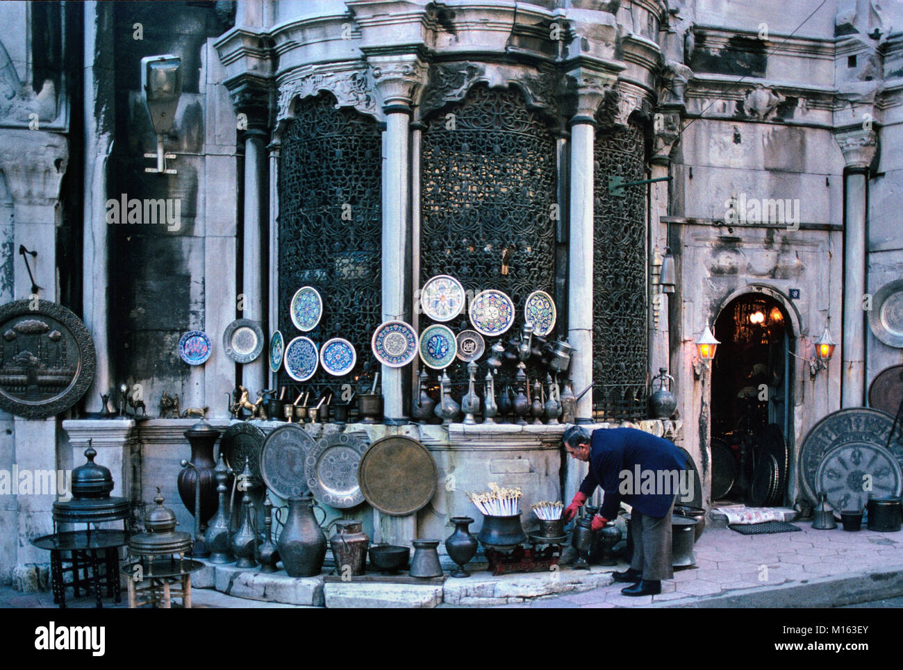 Marktstand oder Ladenbesitzer außerhalb des überdachten Basar oder Grand Basar verkaufen Ware aus Kupfer, Zinn und Porzellan Teller oder Keramik, Istanbul, Türkei Stockfoto
