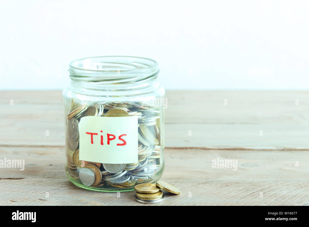 Münzen in Glas Glas mit Tipps label. Geld sparen, Tipps und Spendenkonzept, kopieren. Stockfoto