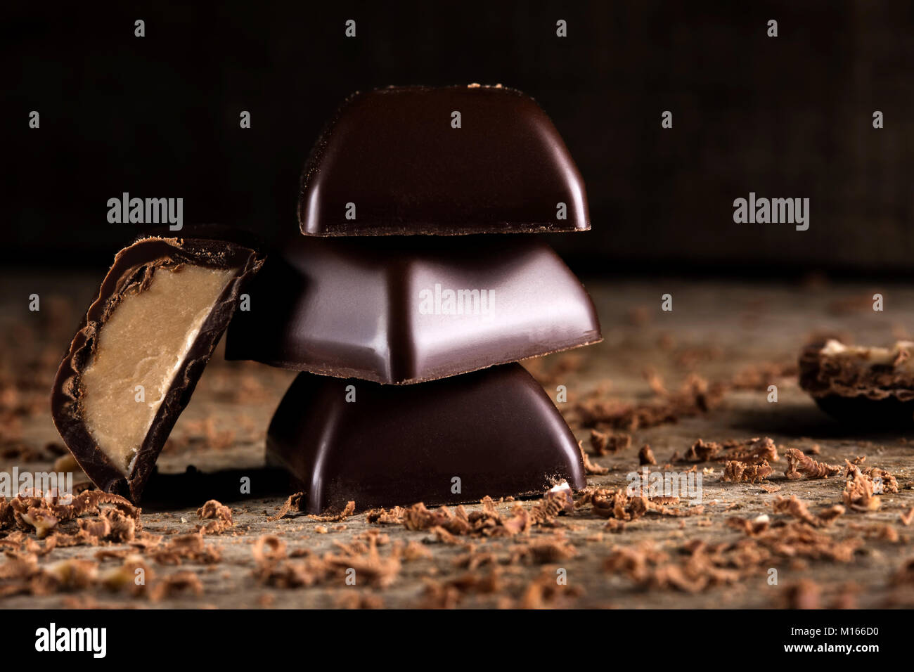 Stücke Schokolade mit Sahne über Holz- rustikalen Hintergrund Stockfoto