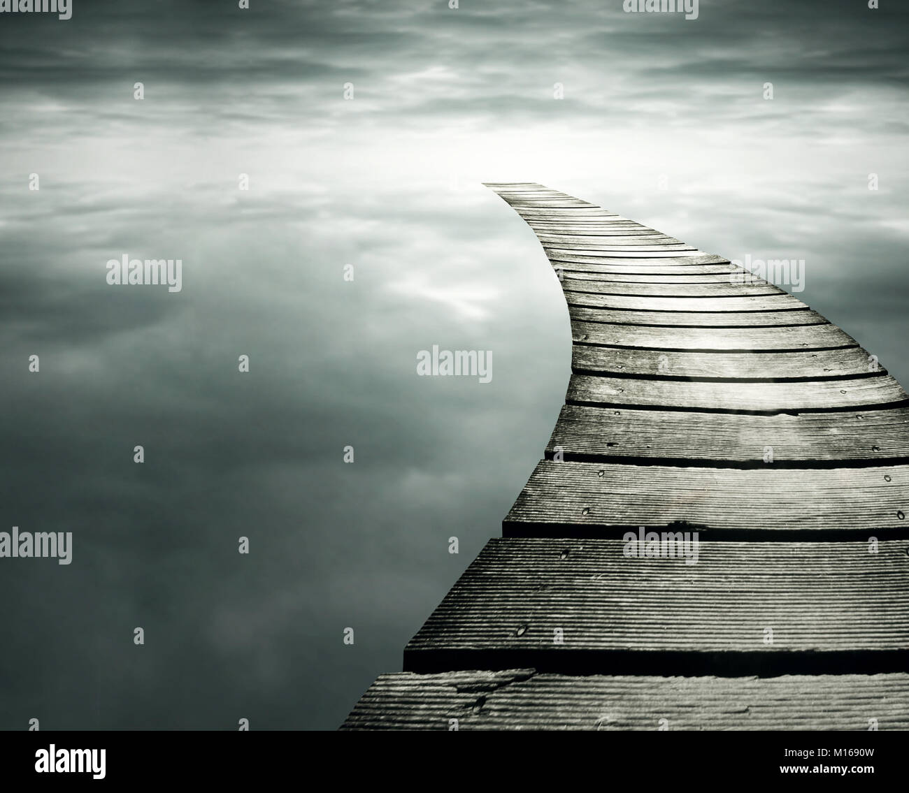 Schöne konzeptionelle Hintergrund mit einem hölzernen Weg in die Unendlichkeit Dramatischer Himmel Stockfoto
