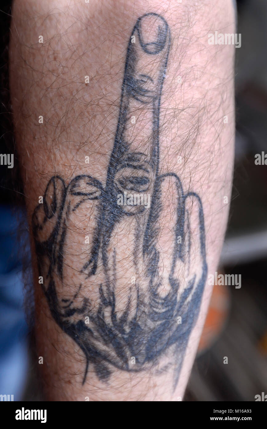 Tattoo mit Mittelfinger auf dem Arm, Deutschland Stockfoto