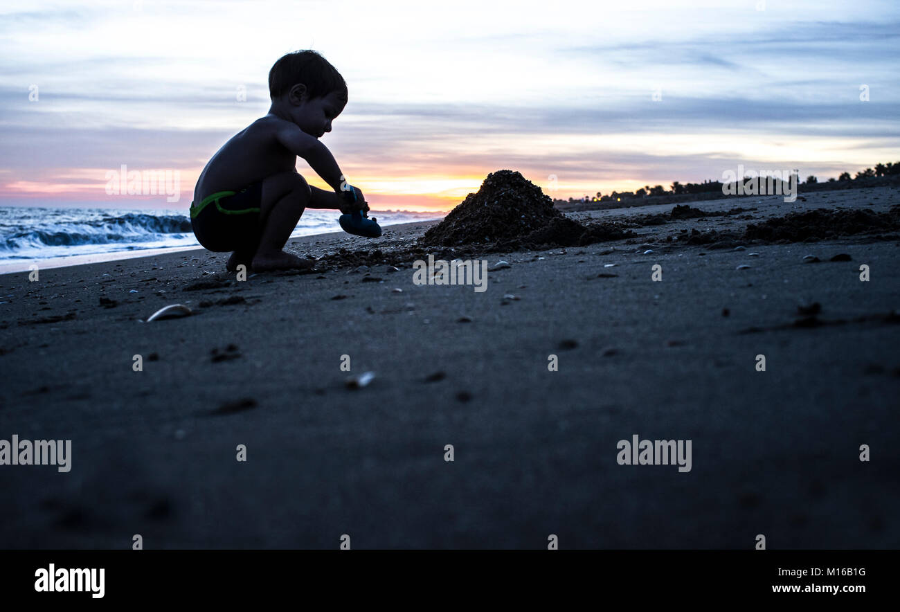 Sonnenuntergang baby boy sand Schaufel. Strand von Islantilla, Costa de la Luz, Huelva, Spanien Stockfoto