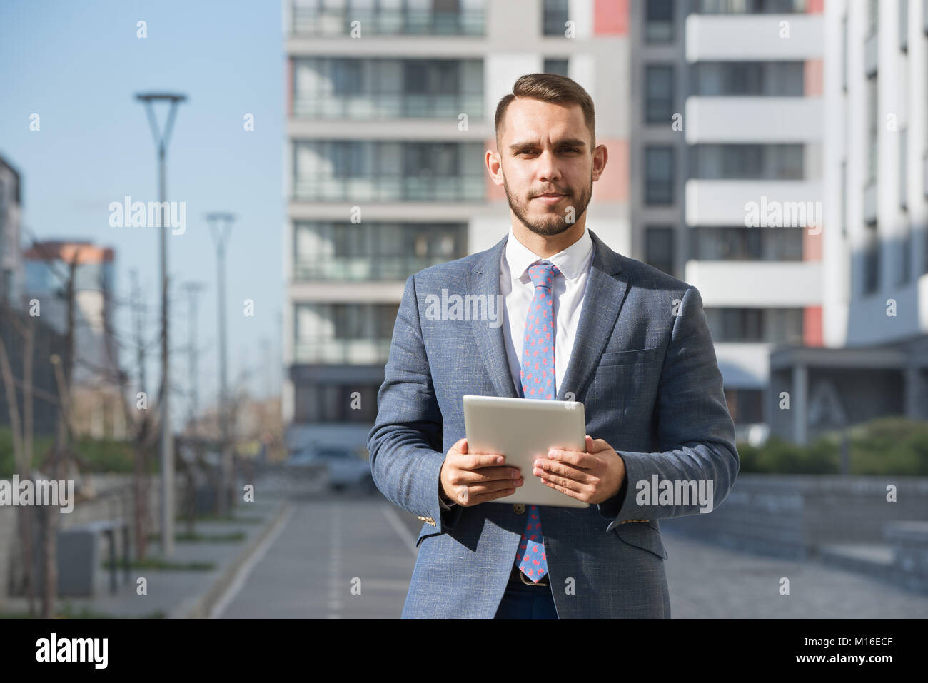 Geschäftsmann oder real estate agent mit Tablet Computer gegen neue Gebäude Stockfoto