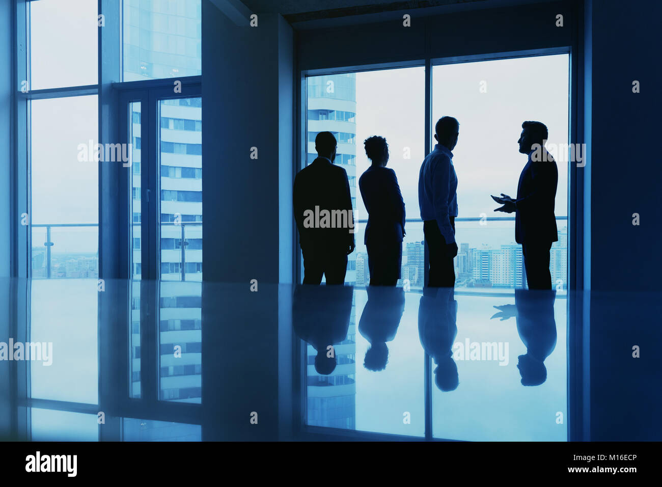 Bürokonzept mit Mitarbeitern Silhouetten gegen große Fenster Stockfoto